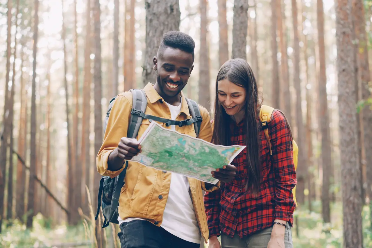 Deux personnes consultent une carte ensemble en forêt lors d'une course d'orientation en équipe