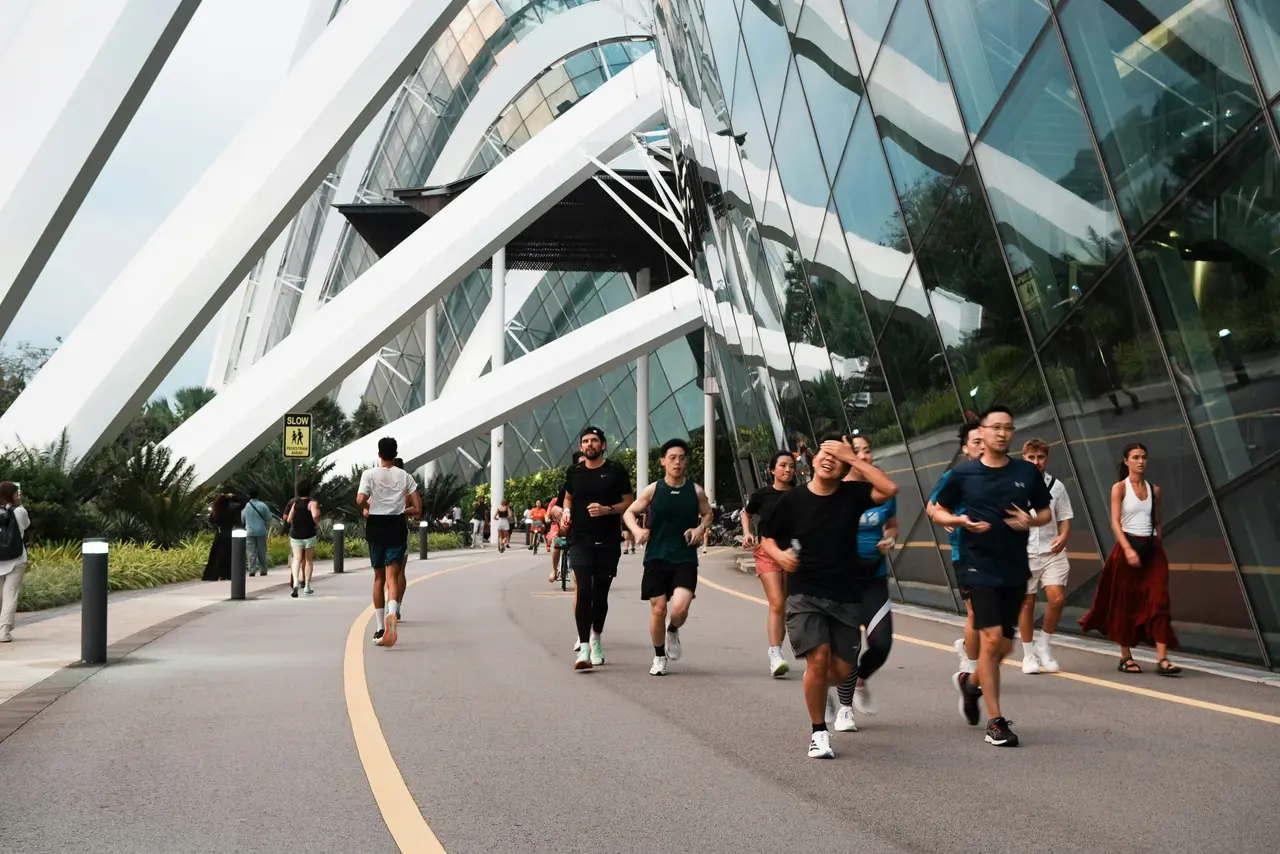 Groupe de coureurs longeant un bâtiment vitré lors d'un trail urbain en entreprise