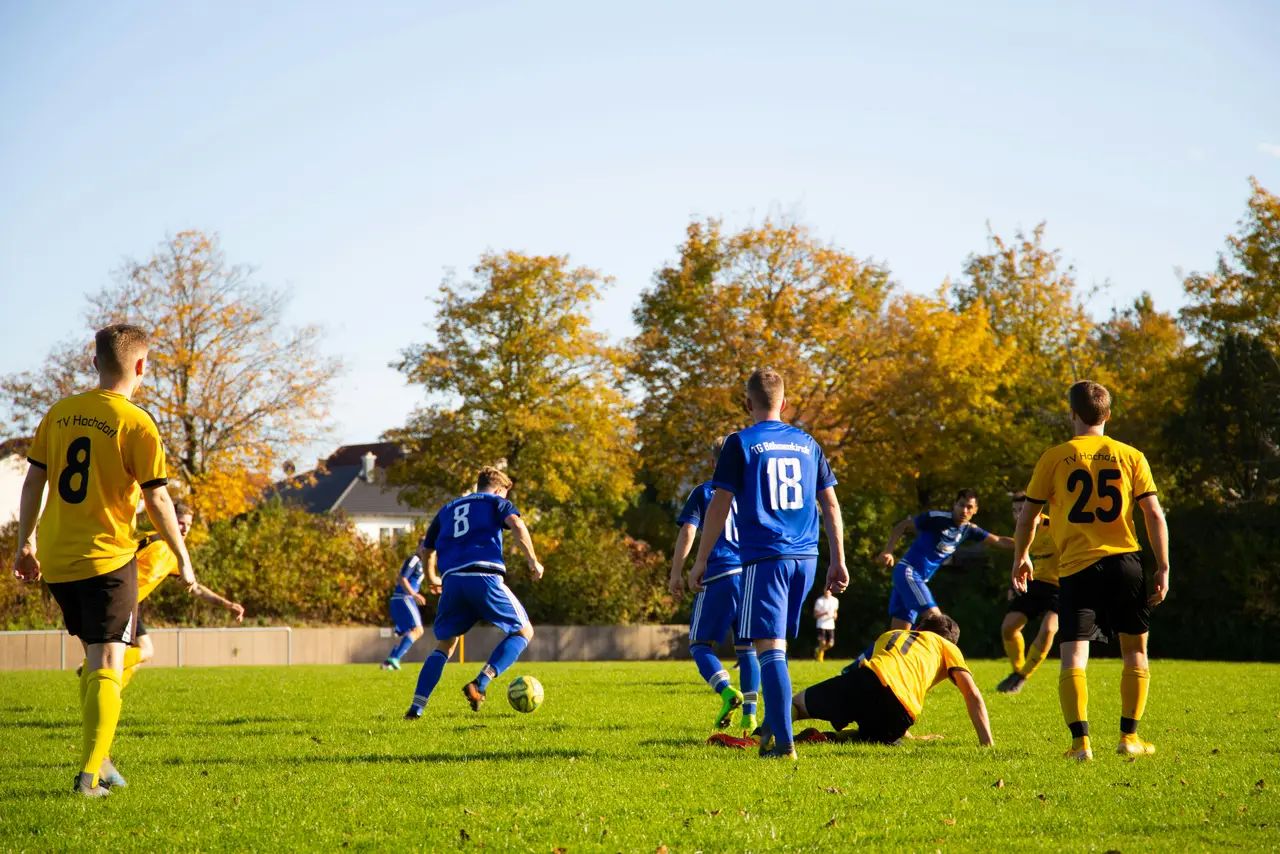Match de football amical entre collègues sur un terrain herbeux en automne