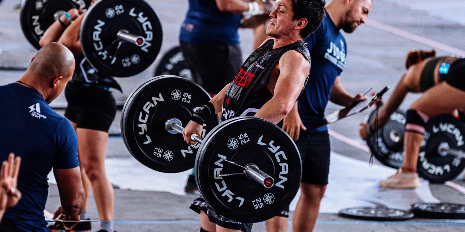 Athlète en plein soulevé de terre pendant un WOD collectif dans une box de CrossFit